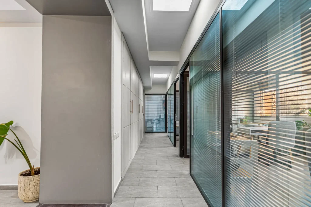 Hallway leading to private offices with glass partitions